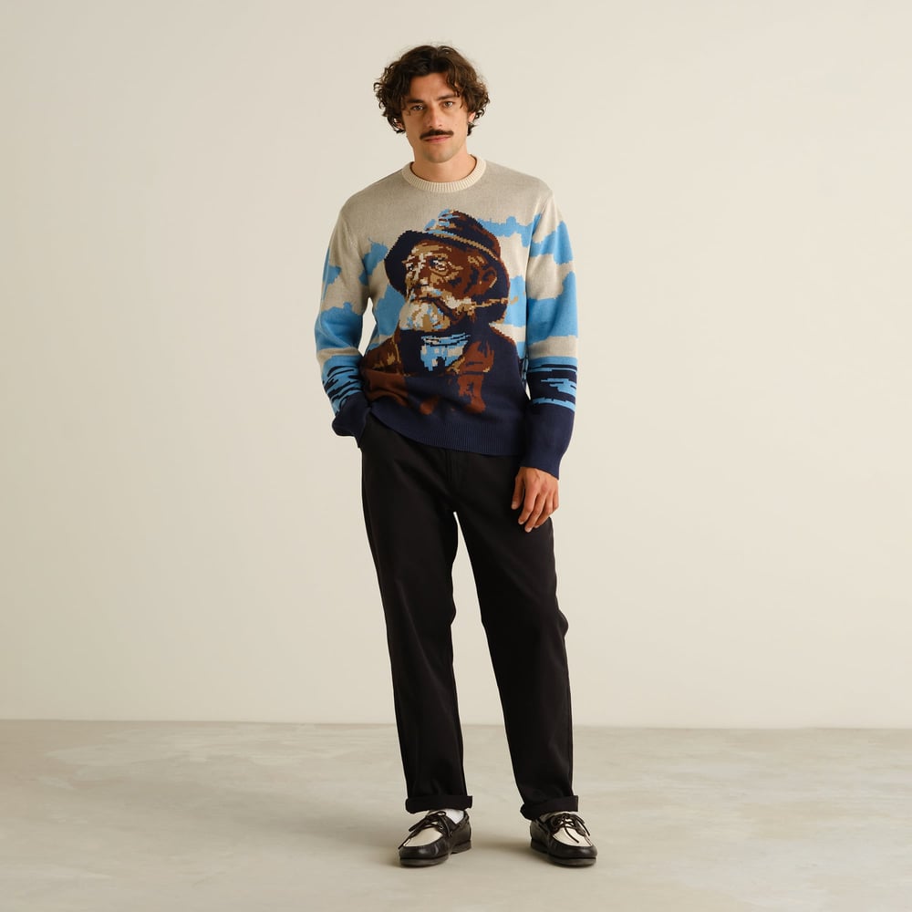 A model creates a cool, retro look with the Sweater Mora Man and Sea, black trousers, and two-tone shoes.