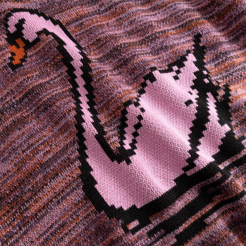 Close-up of the Sweater Arendal's jacquard knit, featuring a retro pixelated pink swan on a multi-colored background.