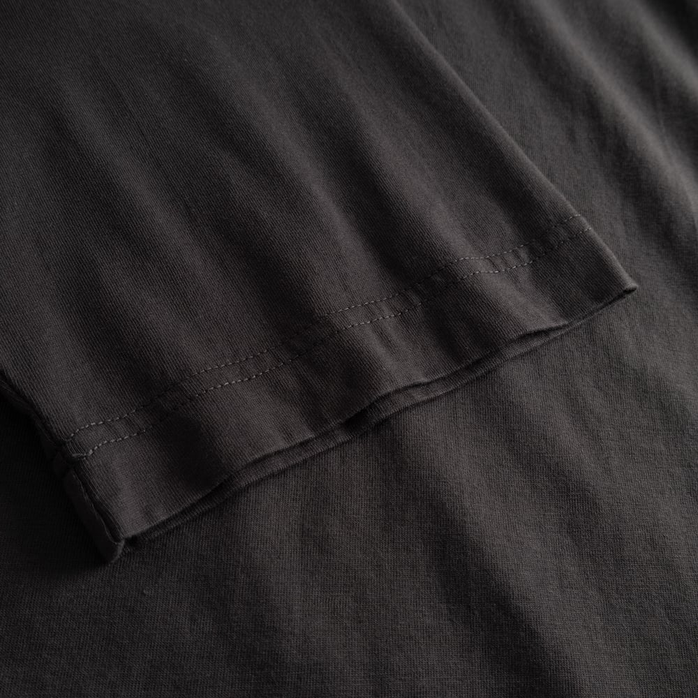 A close-up of the charcoal T-shirt Vadstena, highlighting the detailed stitching on the sleeve.