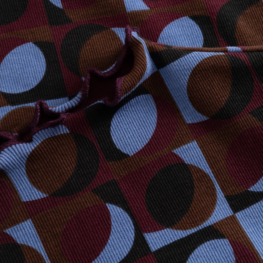 A close-up of the Rib Top Ryd, showing the wavy lettuce seam and colorful Retro Geo print on the ribbed fabric.