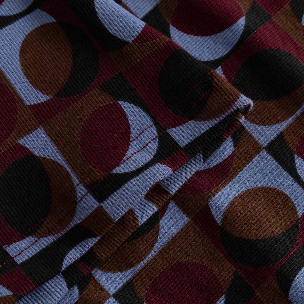 Close-up on the Rib Top Malma's ribbed fabric, showing the retro geo print in blue, burgundy, brown, and black.