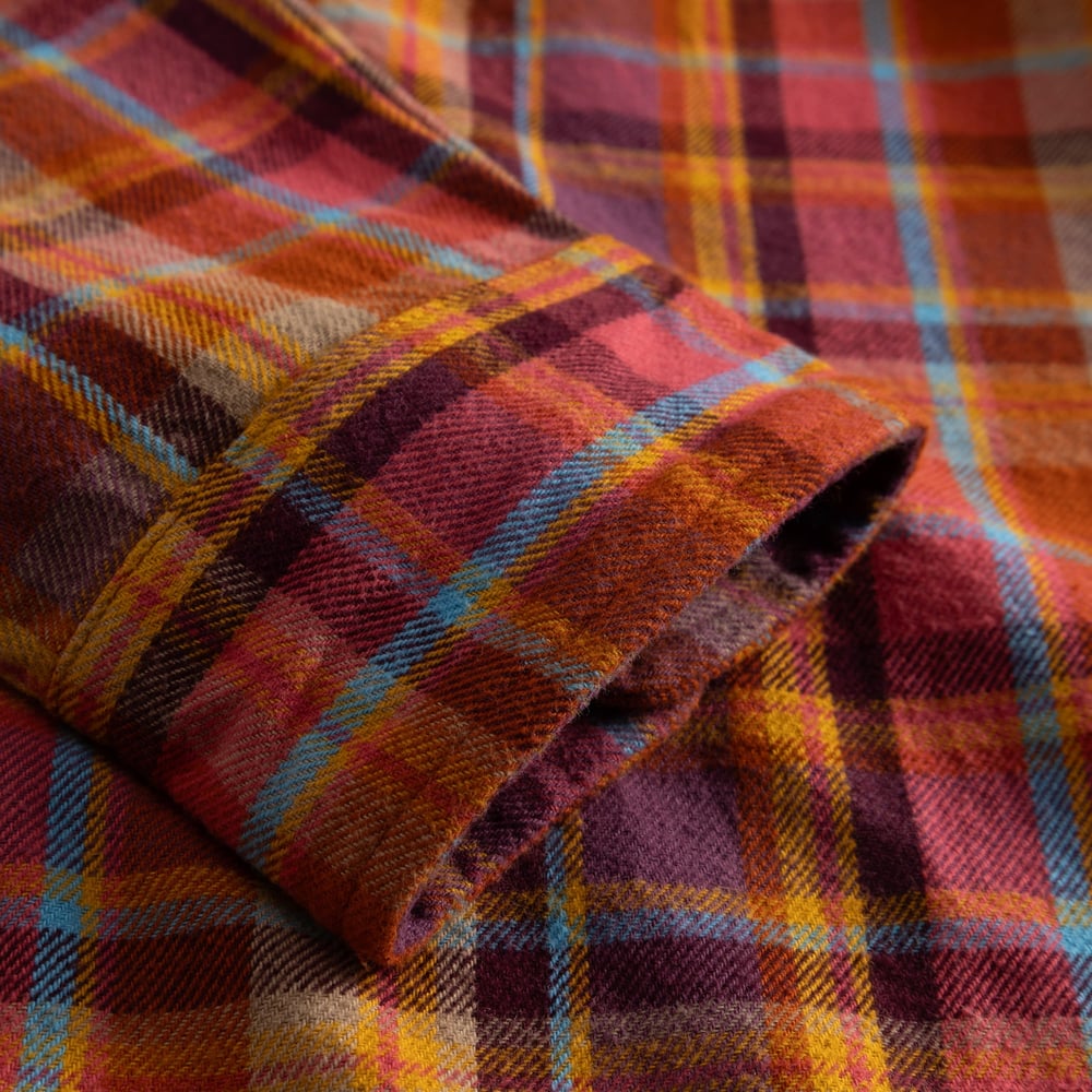 Close-up on the sleeve cuff of the Rute Flannel Shirt, showing the soft texture of its multi-colored madras check.