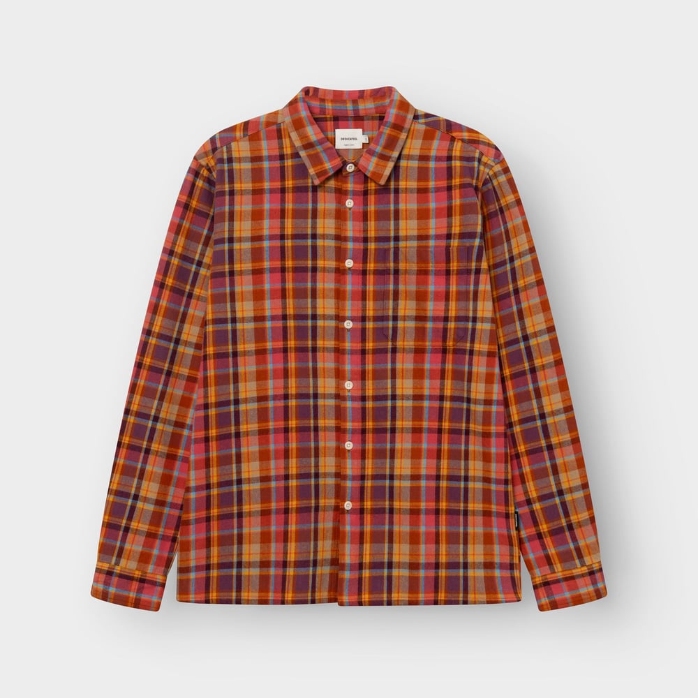 Front view of the Rute flannel shirt in a warm madras check of red, orange, and blue, laid flat on a light background.