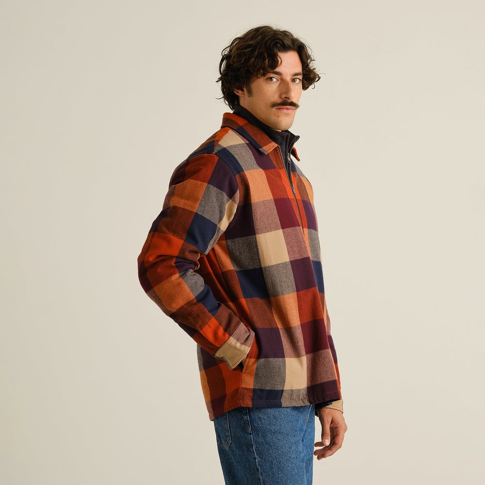 A model with his hand in his pocket, showing off the side profile of the colorful Torp Flannel Check Jacket.