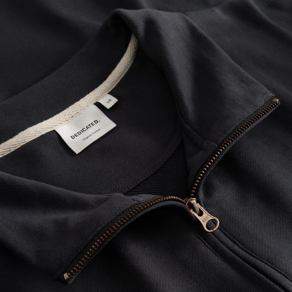 A close-up view of the Half Zip Sweatshirt Sandvalla in Phantom Black, highlighting the collar, metal zip, and brand label.