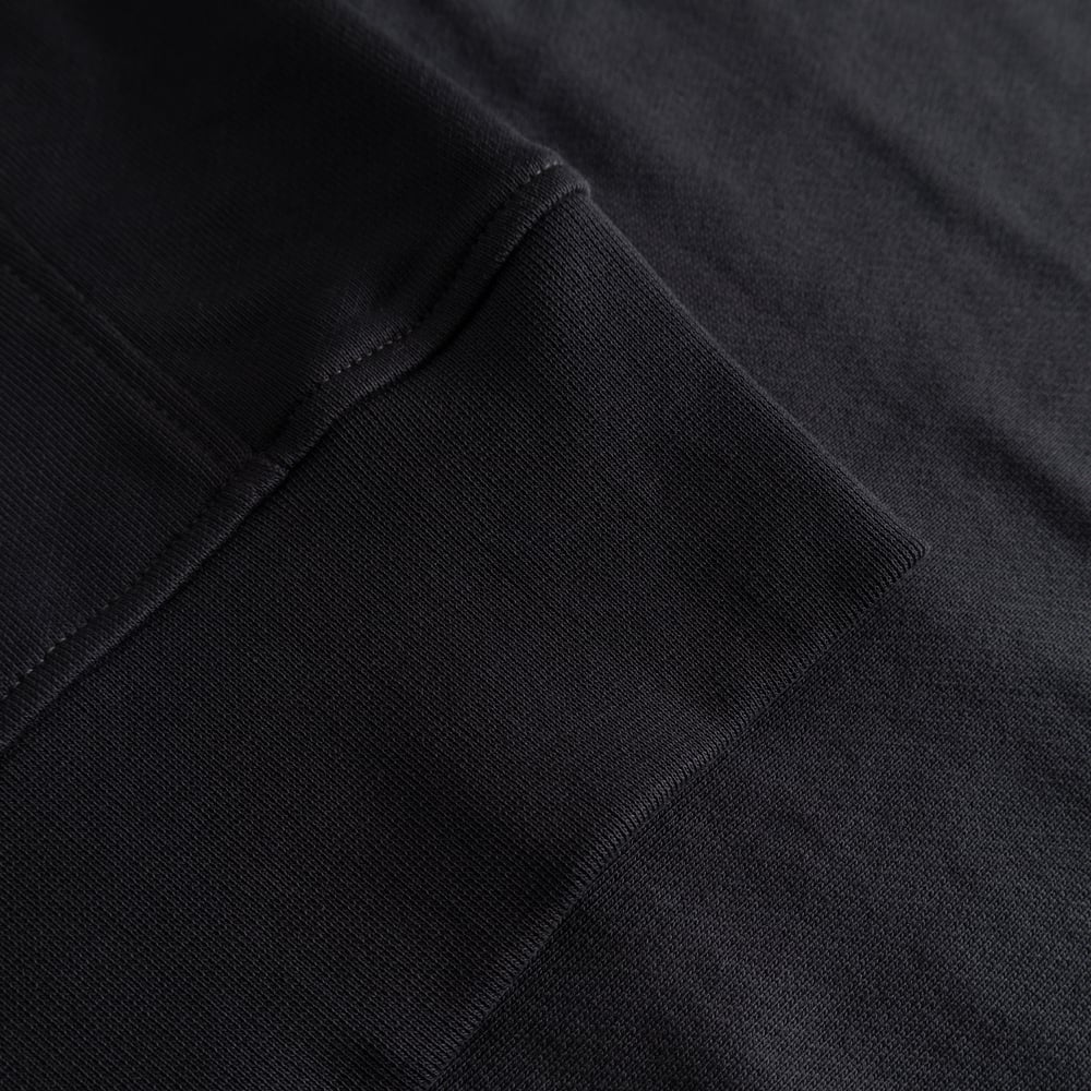 A close-up of the soft, ribbed cuff on the heavyweight organic cotton Bettna Sweatshirt in Phantom Black.