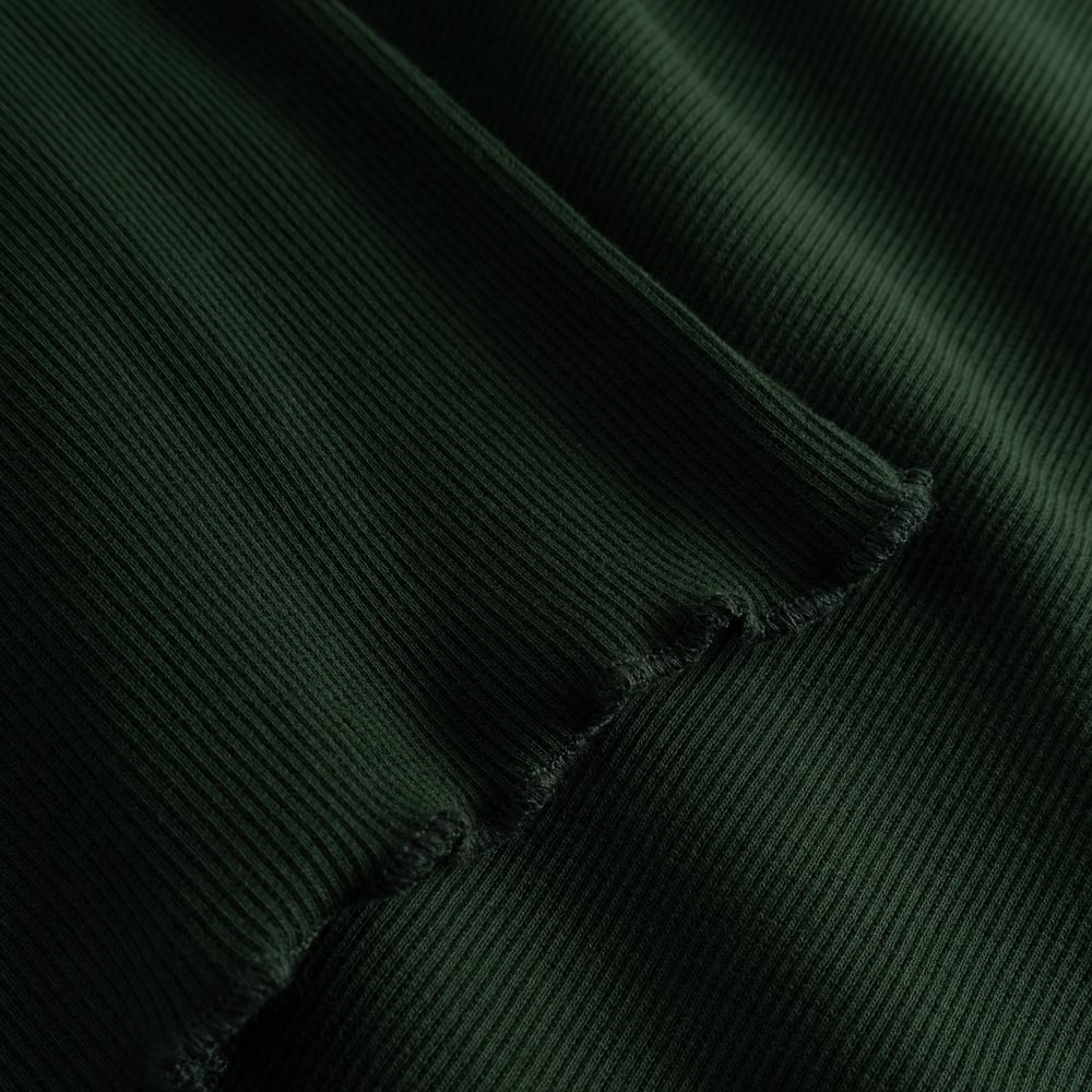 A close-up of the Rib Top Ryd in Dark Green, showing the soft ribbed texture and delicate wavy finish of the lettuce seam.