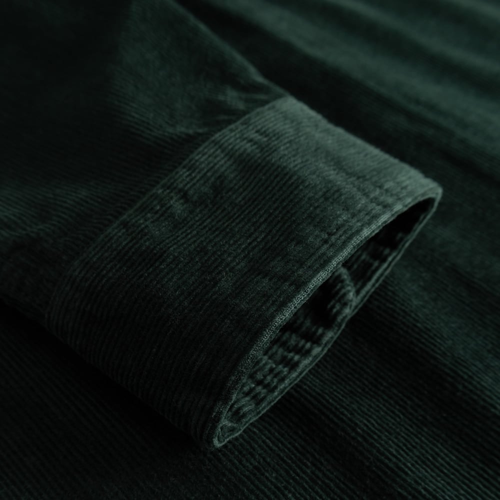 Close-up of the cuff on the Shirt Varberg, showcasing the rich, dark green corduroy fabric.