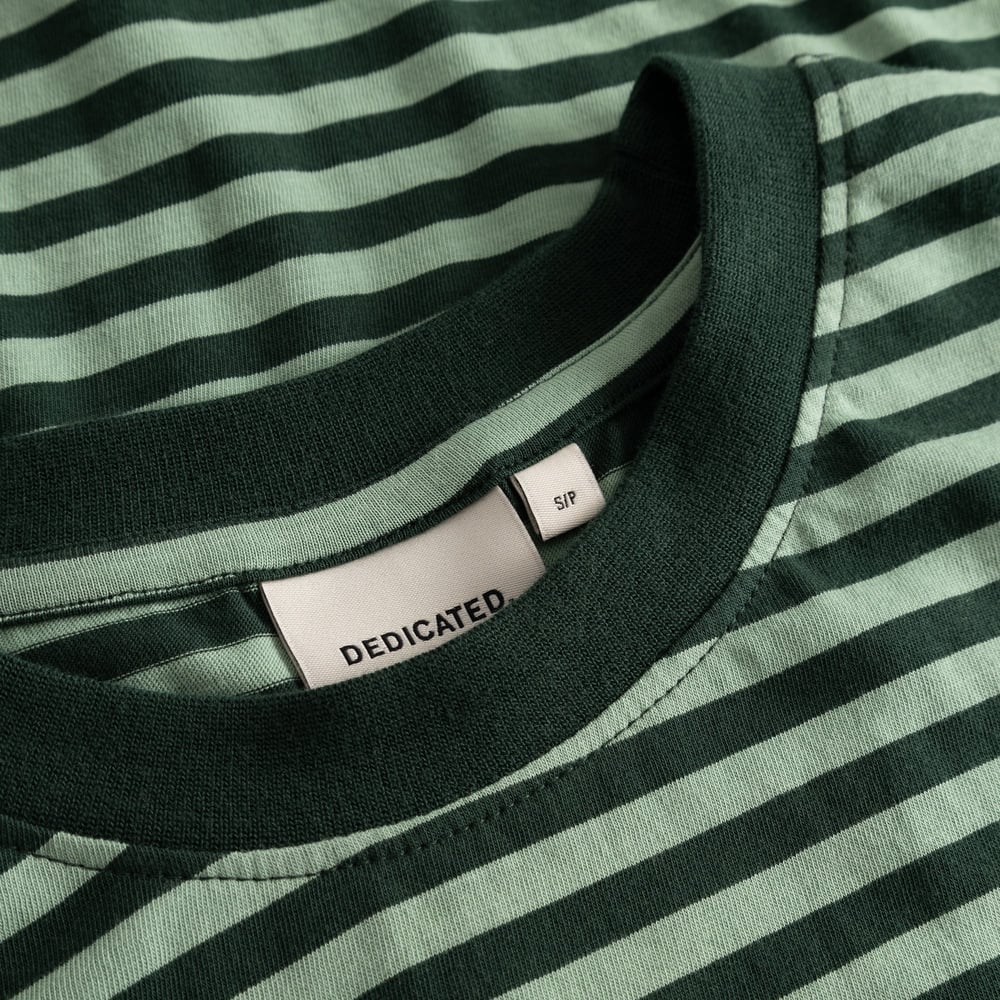 Close-up of the brand label and dark green collar on the striped T-shirt Vadstena in Dark Green/Granite Green.