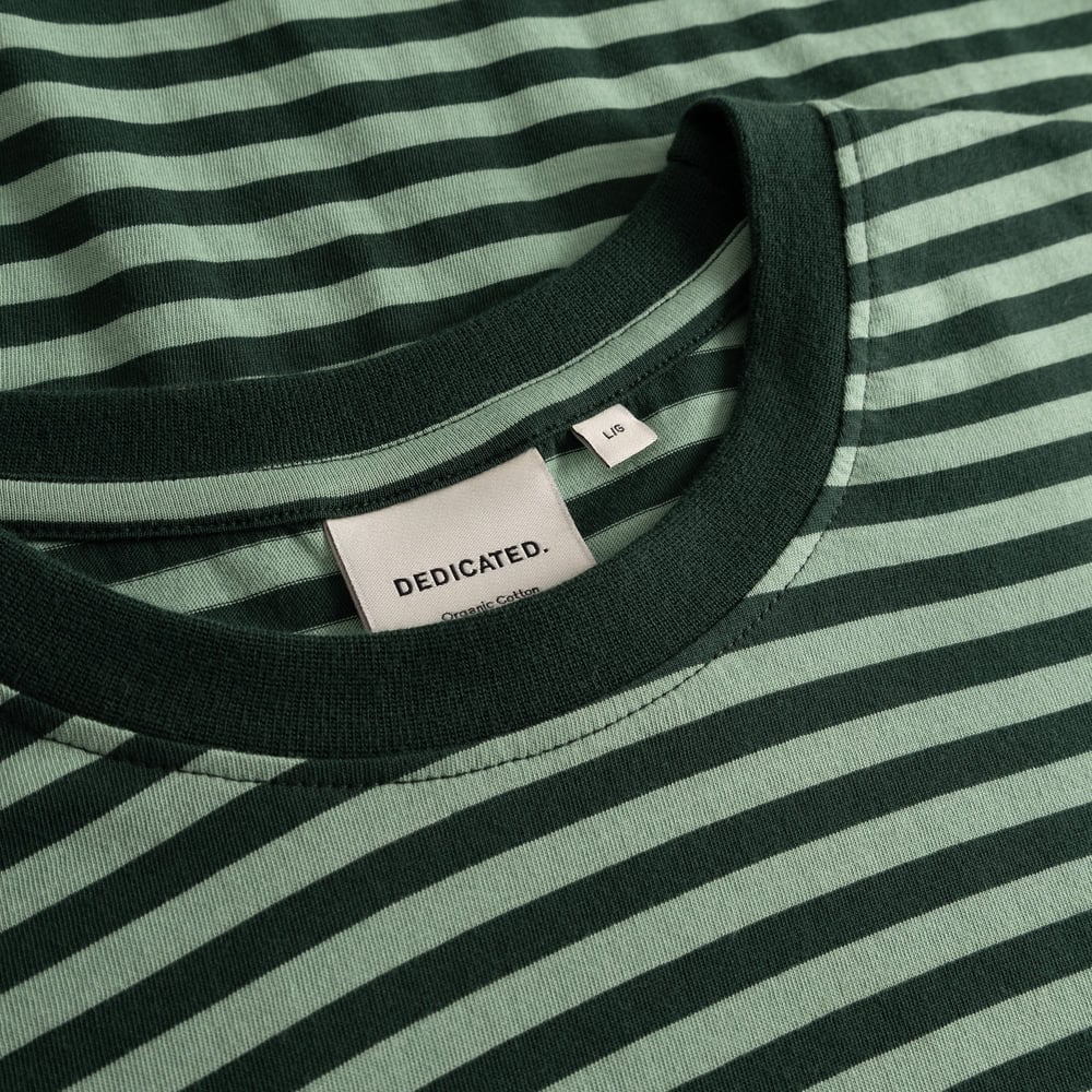 Detail shot of the T-shirt Stockholm in Pine Grove and Granite Green stripes, focusing on the crew neck and Dedicated label.