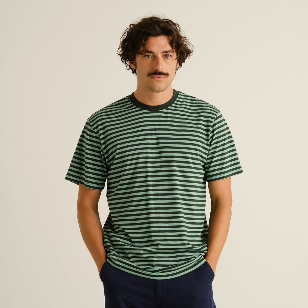 Front view of a male model wearing the striped Stockholm t-shirt in dark green and granite green.