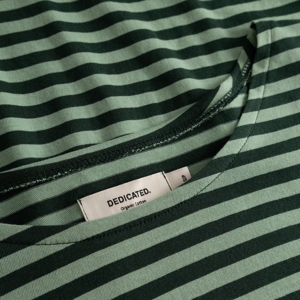 Close-up of the Humledal top, highlighting the dark and granite green striped organic cotton and the Dedicated label.