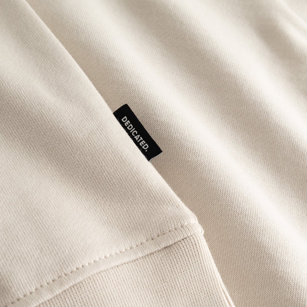 A close-up of the Sweatshirt Ystad in Oat White, highlighting the soft fabric and the signature Dedicated side label.