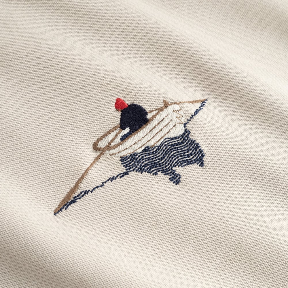 A detailed close-up of the rowing boat embroidery on the chest of the oat white Sweatshirt Malmoe.