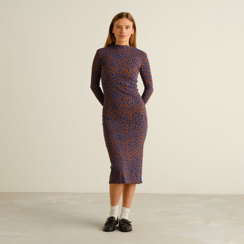 Front view of a model wearing the slim-fit Rib Dress Lofta in a playful brown and blue leopard print.