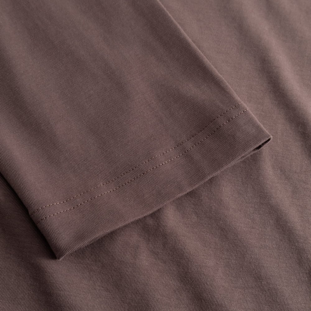 A detailed close-up of the sleeve on the Vreta long-sleeve T-shirt, showing the fine stitching and soft Sparrow Brown fabric.