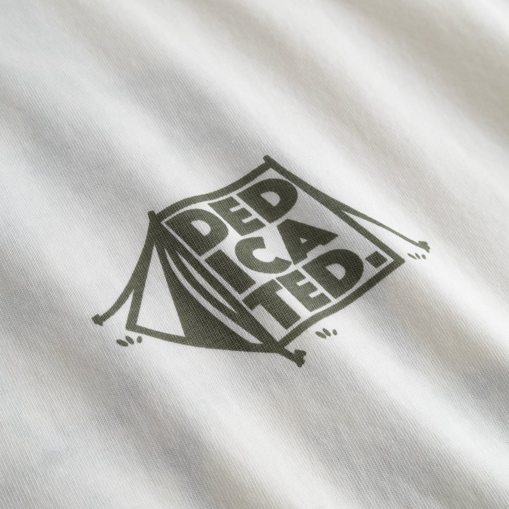 Close-up shot of the off-white T-shirt Stockholm, detailing the green 'Dedicated' tent graphic on the organic cotton fabric.