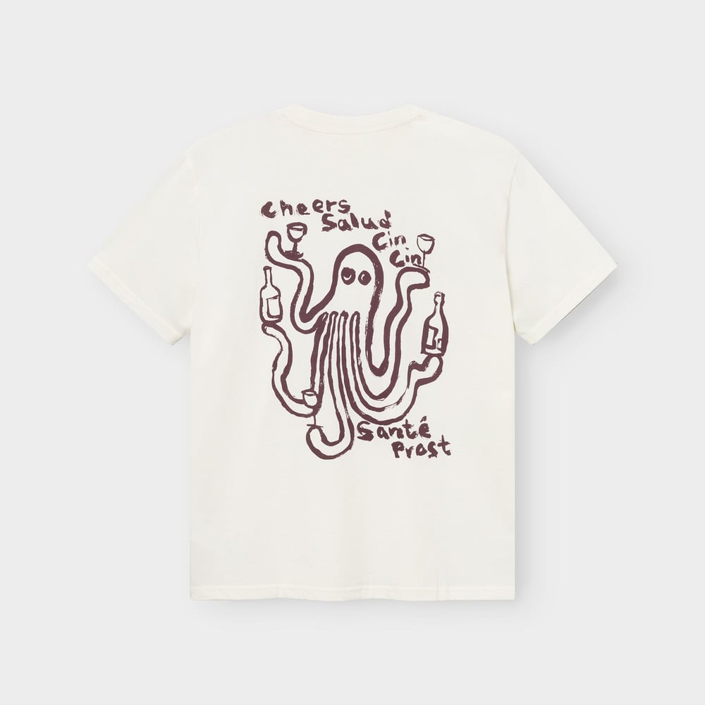 Rückansicht eines cremeweißen T-Shirts mit Oktopus-Print, der Weingläser hält, und „Cheers“ in mehreren Sprachen.