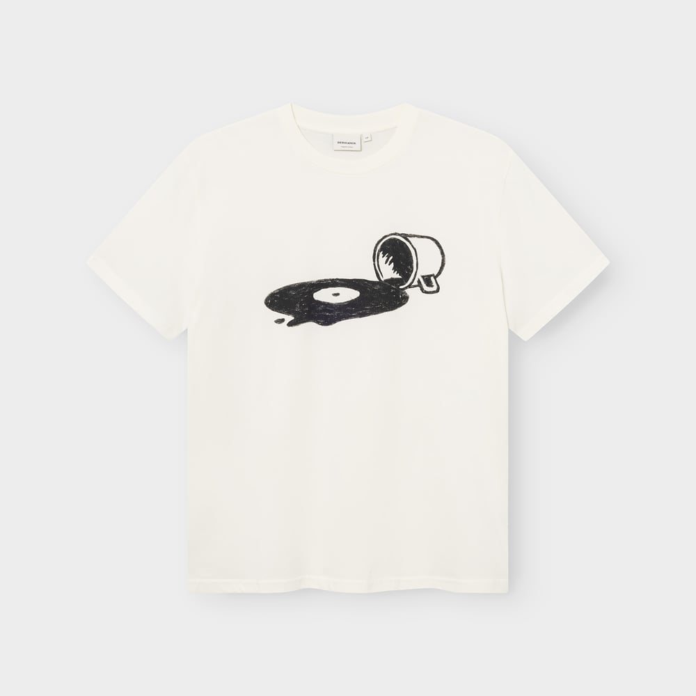 A flat lay of the T-shirt Stockholm Spilled in off-white, with its unique graphic of a cup spilling out a vinyl record.