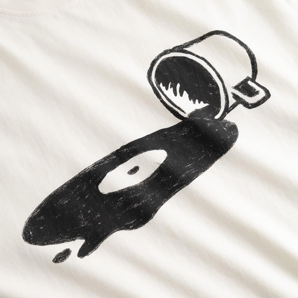 Close-up on the chest of the off-white T-shirt Stockholm Spilled, showing the quirky spilled coffee and vinyl record graphic.