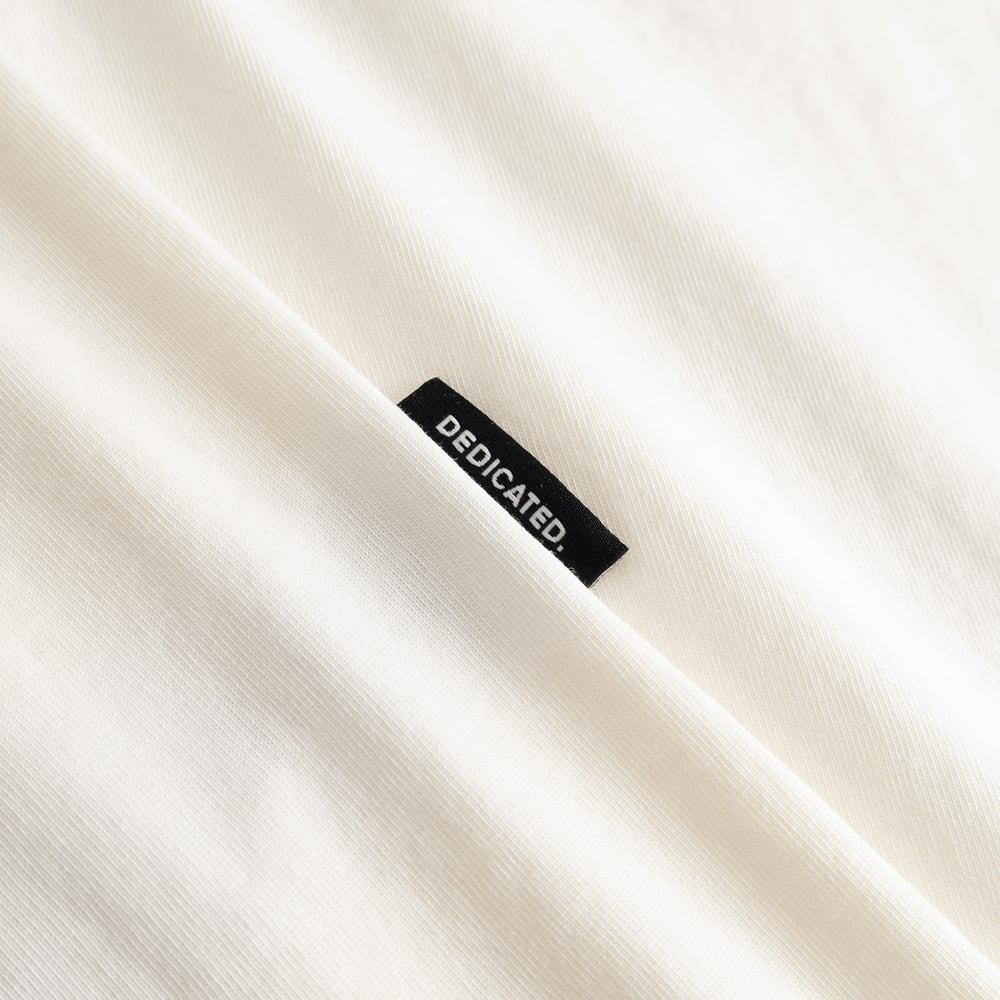 A detailed shot of the T-shirt Stockholm Spilled Off-White, highlighting the soft fabric and the signature Dedicated tag.