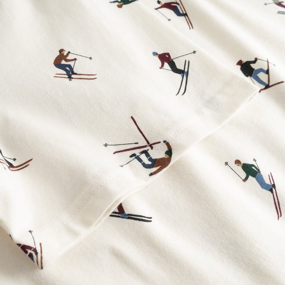 Close-up detail of the off-white Stockholm Ski Team t-shirt, showing the all-over print of colorful skiers on the sleeve.