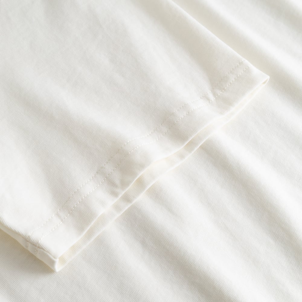 A close-up shot of the sleeve on the off-white T-shirt Stockholm Perch EMB, highlighting the soft organic cotton fabric.