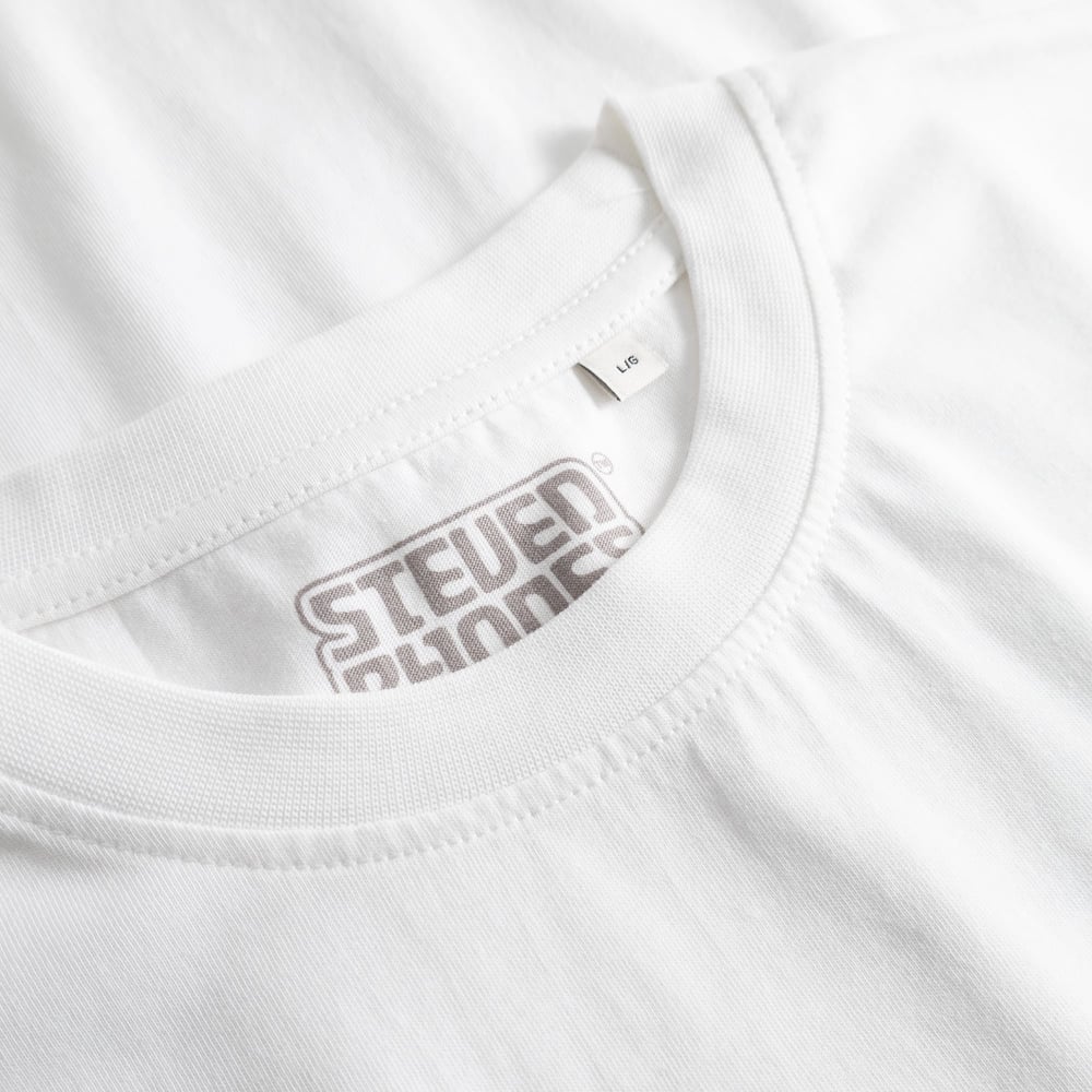 Close-up of the ribbed crew neck on the white T-shirt Stockholm, showing the Steven Rhodes printed label inside.