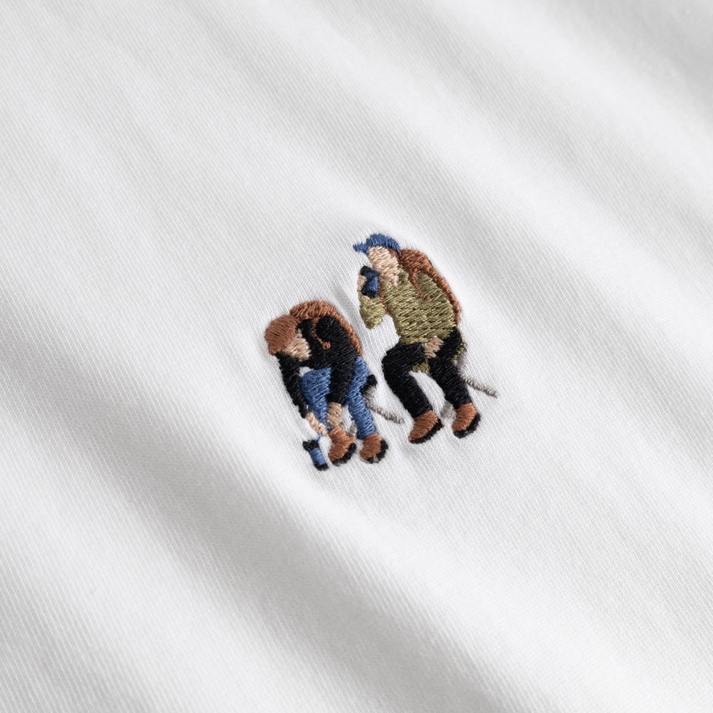 Close-up of the detailed 'Camp Crew' embroidery on the chest of a white t-shirt.