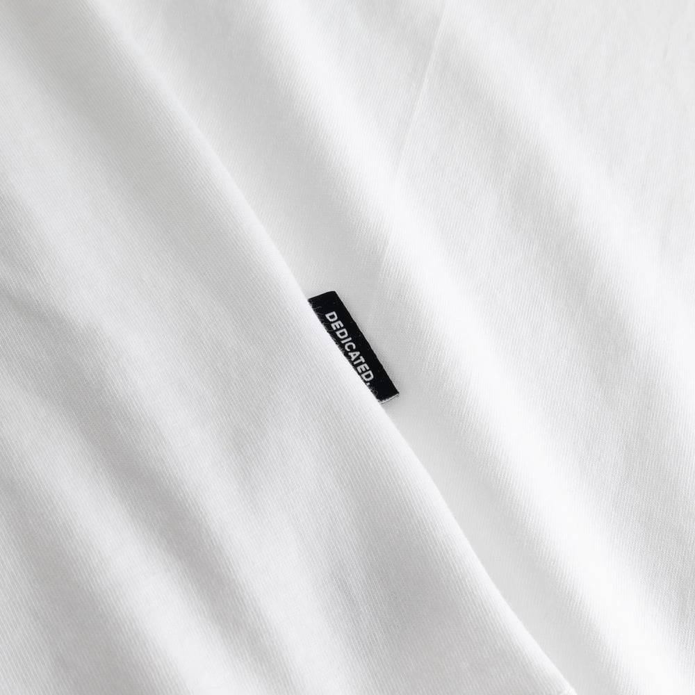 Detail shot of the white T-shirt Stockholm showing the soft fabric and our classic black and white Dedicated brand tab.