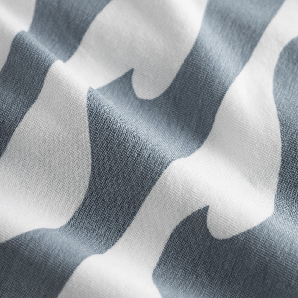 Nahaufnahme des weichen Bio-Baumwolljerseys der Kalix Boxershorts mit weiß-blauem Wellenmuster.