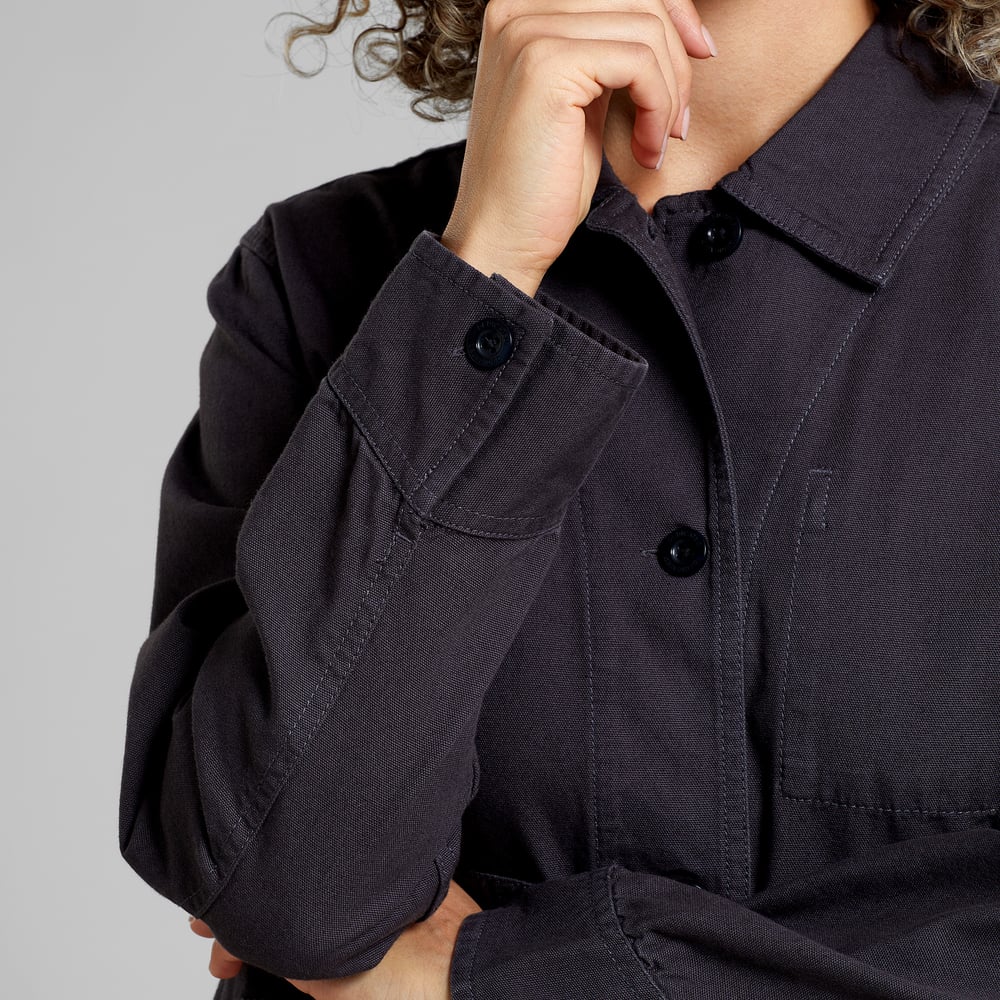 A model wears the relaxed-fit Stiby shirt jacket in Phantom Black, showing a close-up of the buttoned cuff and collar.