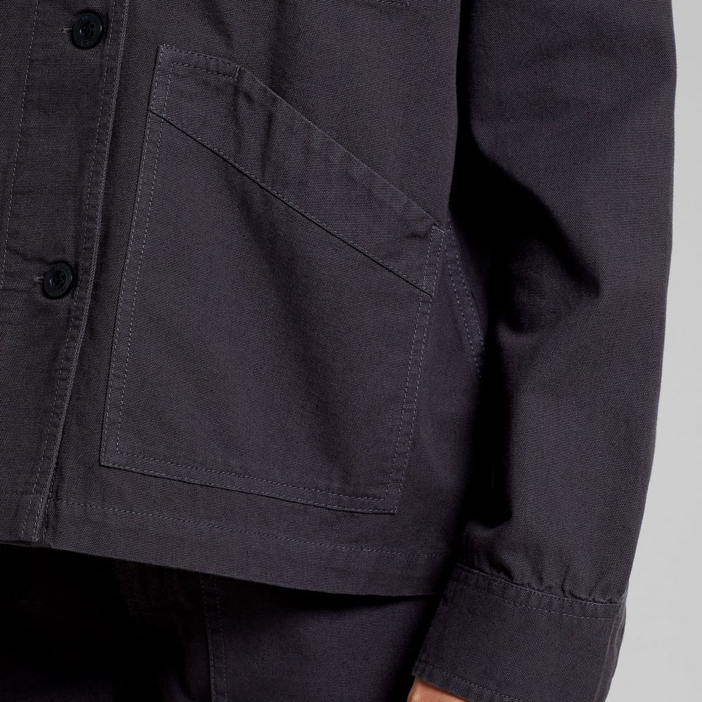 Close-up detail shot of the Stiby Canvas Jacket in Phantom Black, focusing on the angled front pocket and buttoned cuff.