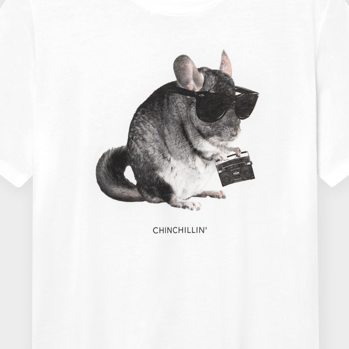 Närbild på det roliga "CHINCHILLIN'"-trycket på den vita T-shirten Stockholm med en chinchilla med solglasögon och boombox.