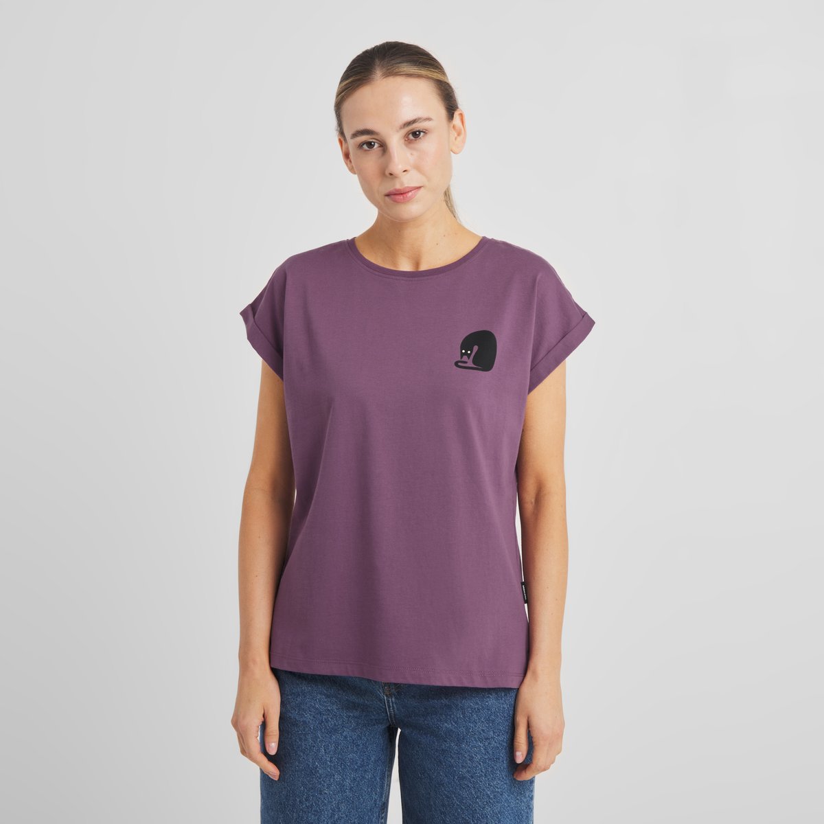 A model wears the T-shirt Visby Curious Cat in Berry Purple, a slim-fit tee with a small cat embroidery on the chest.