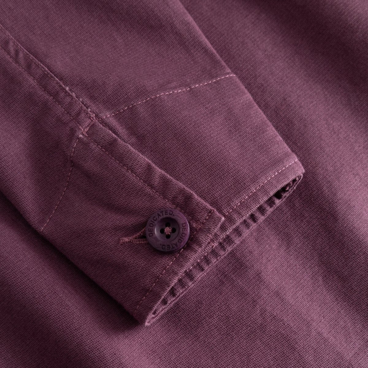 Närbild på manschetten på jackan Stiby Berry Purple som visar det mjuka manchestertyget och en knapp med logga.