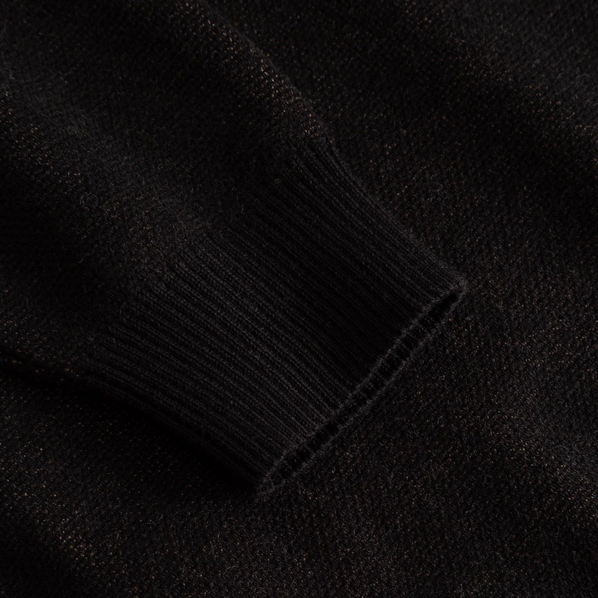 A detailed close-up of the ribbed sleeve cuff on the black Sweater Arendal Long Cat.