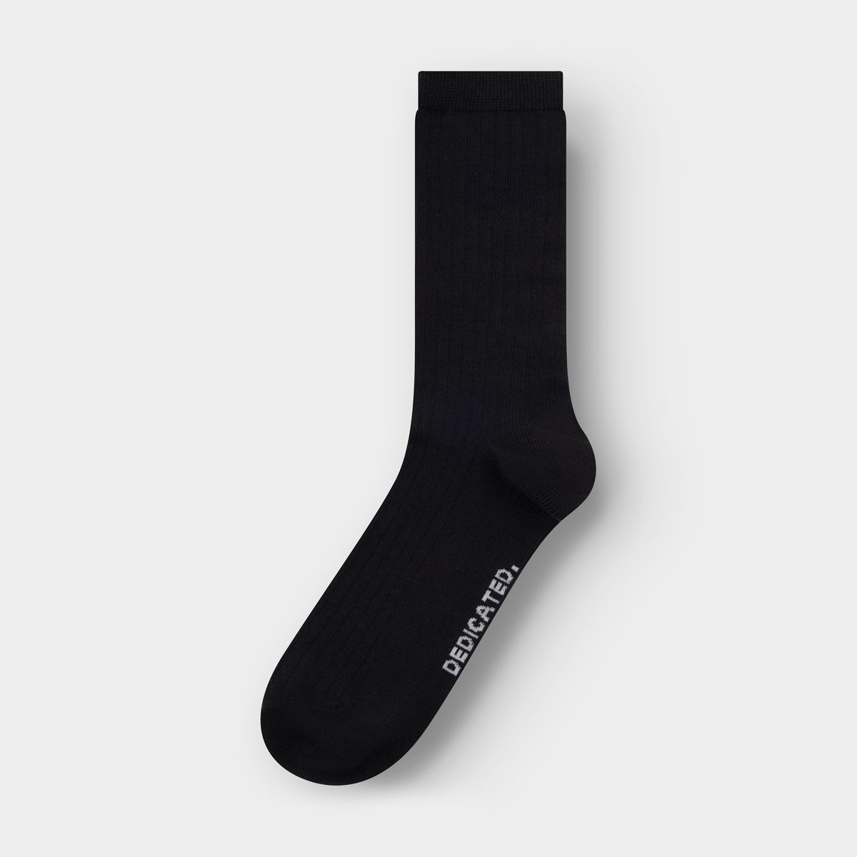 A single black ribbed sock, the Knivsta style, is laid flat on a light grey background.