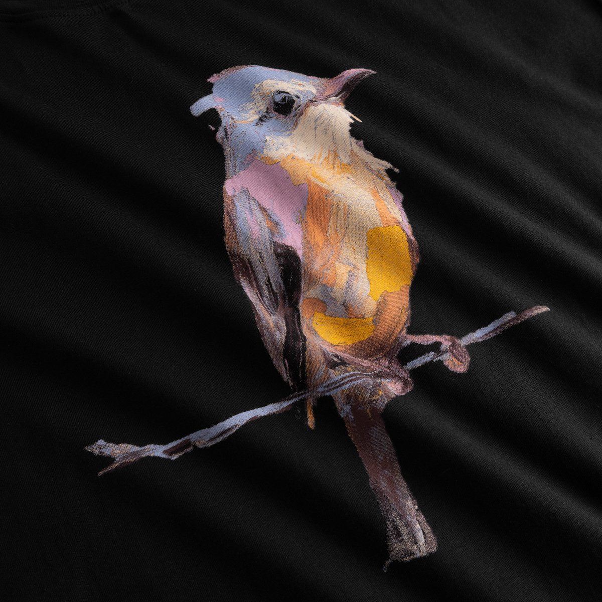 Close-up of the T-shirt Visby Painted Bird in black, highlighting the beautiful, painterly texture of the bird graphic.