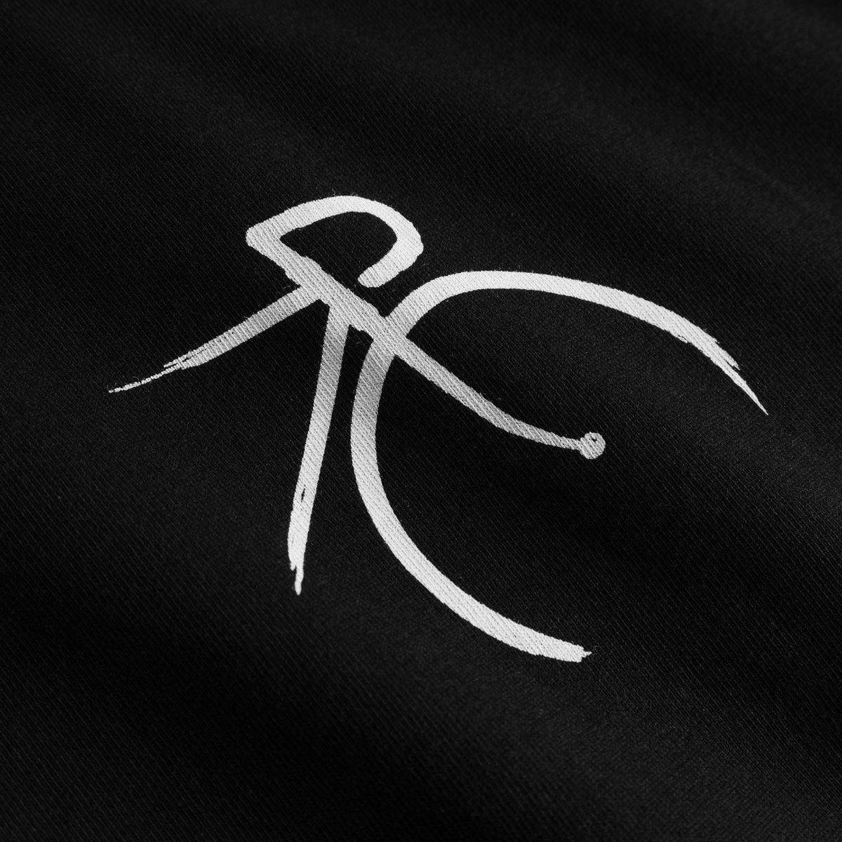 Close-up of the white, brushstroke-style bicycle graphic on the black Stockholm t-shirt.