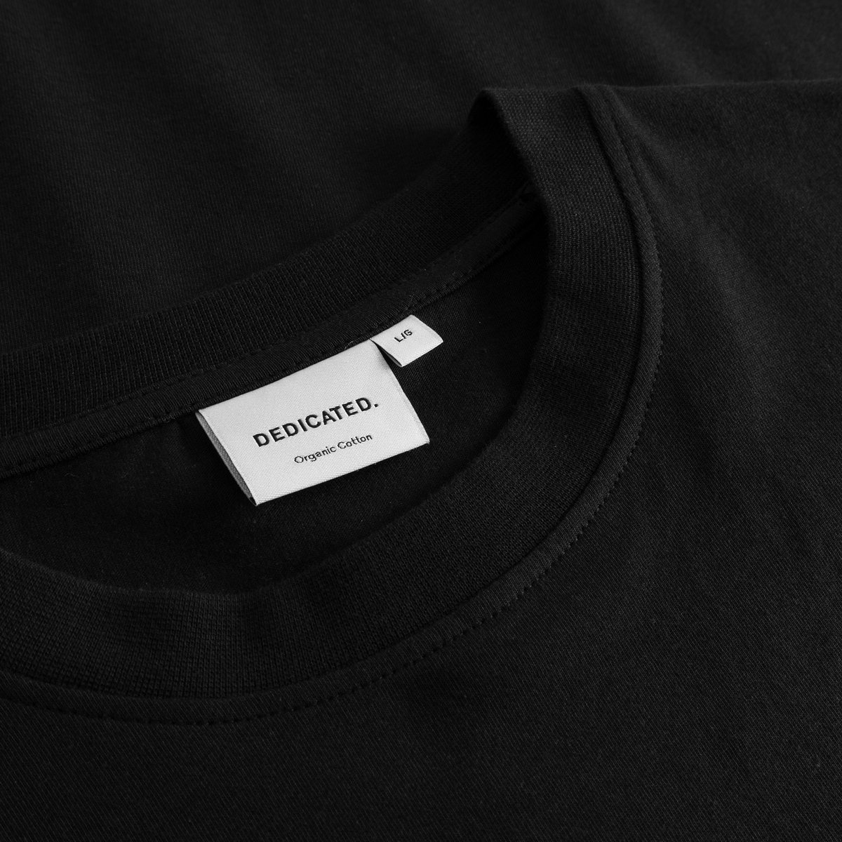 Close-up of the ribbed crew neck and brand label on the black T-shirt Stockholm Cat And Noodles.