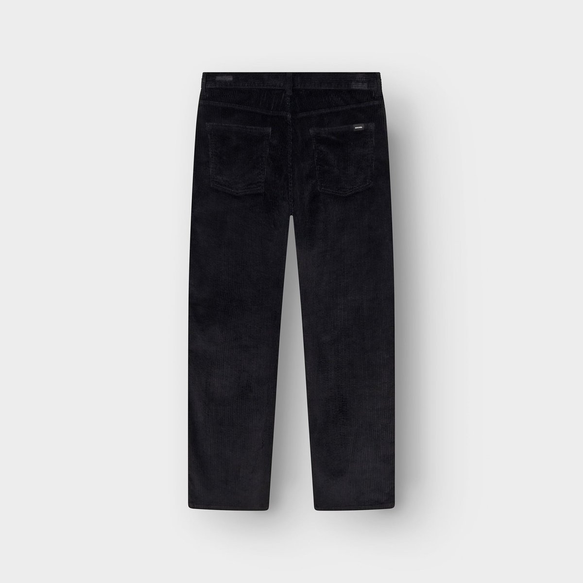 Back view of the Hamburg Corduroy Pants in black, laid flat to show the relaxed fit and back pockets.