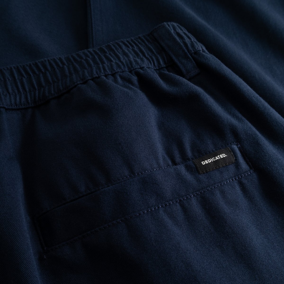 Detailed close-up of the back of the navy Hudiksvall Chino Pants, showing the elasticated waistband and welt pocket.