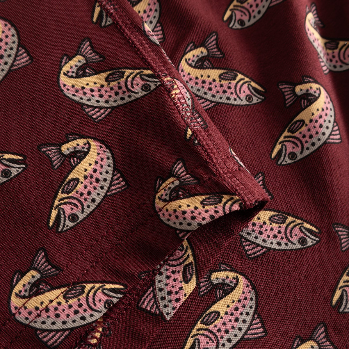 A close-up of the playful trout print on the soft, burgundy fabric of the Kalix Boxer Briefs.