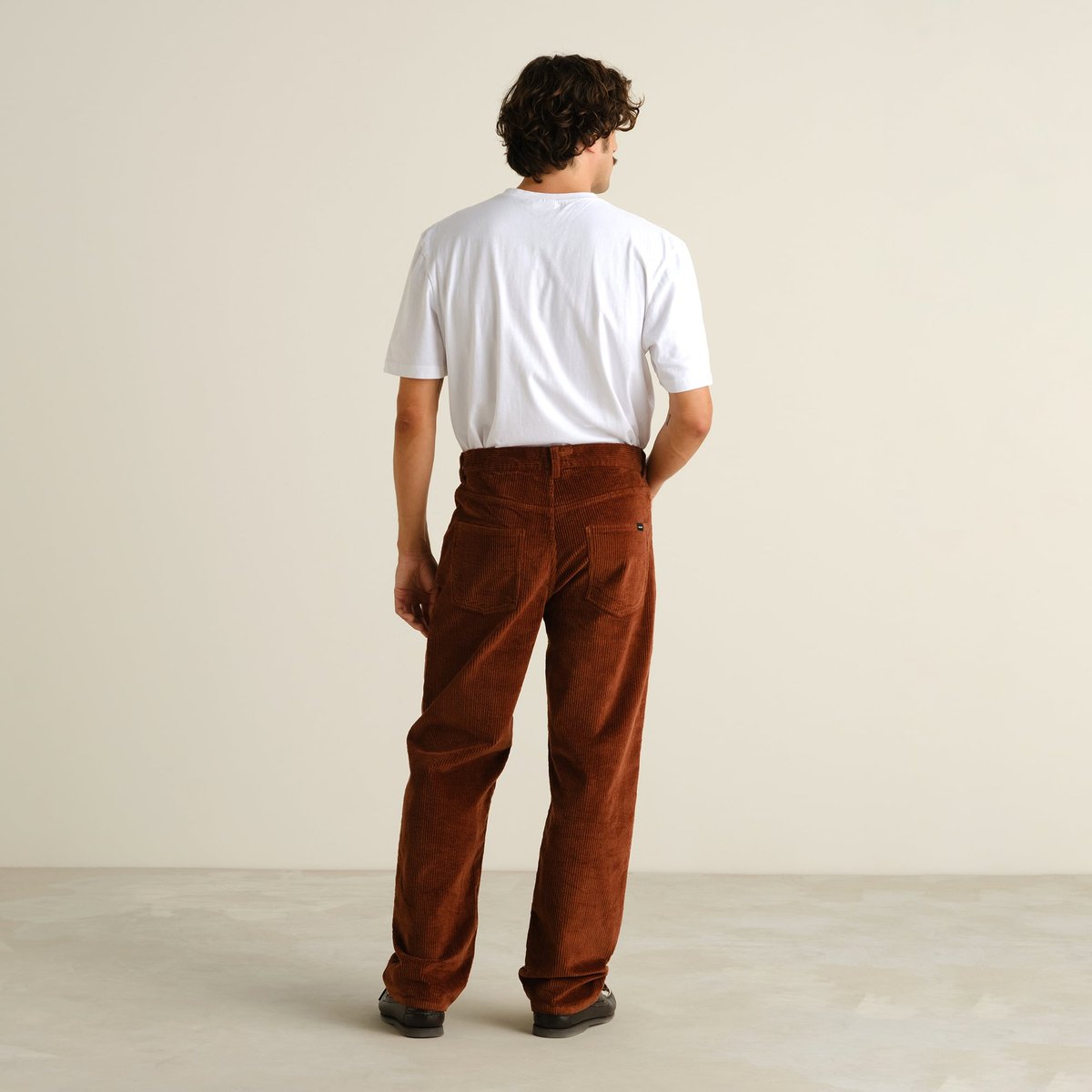 Back view of a model wearing the relaxed-fit Hamburg Corduroy Pants in Cappuccino Brown.