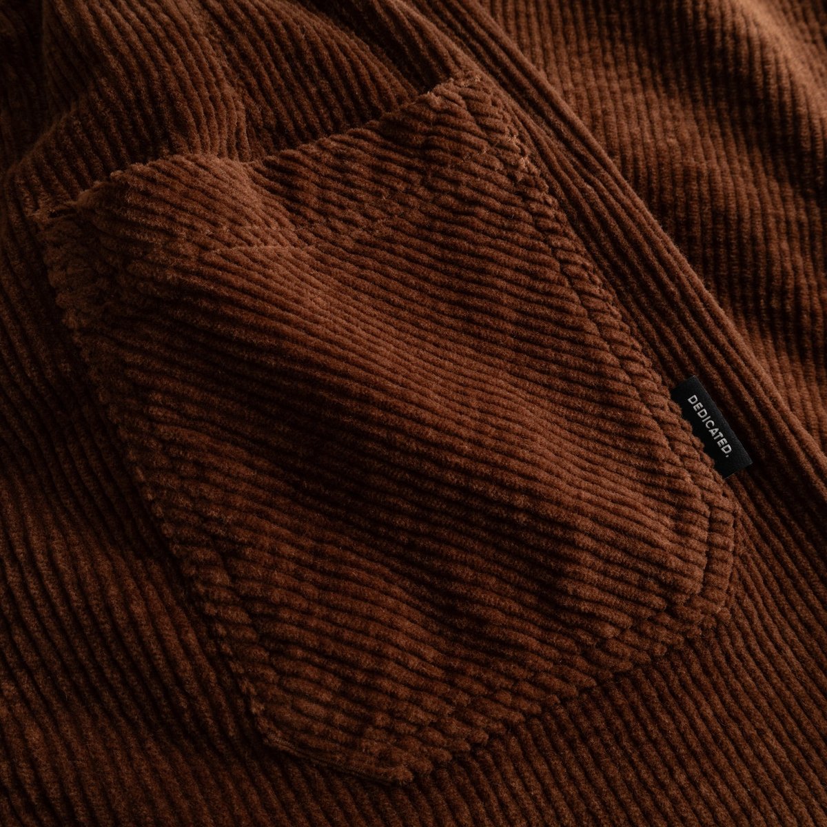 A detailed close-up of the back patch pocket on the Vara Workwear Pants in rich, cappuccino brown corduroy.