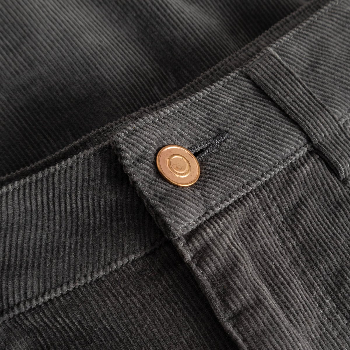 Detailaufnahme des Cordstoffs in Rock Grey und des Knopfes am Bund der Hose Ryda.