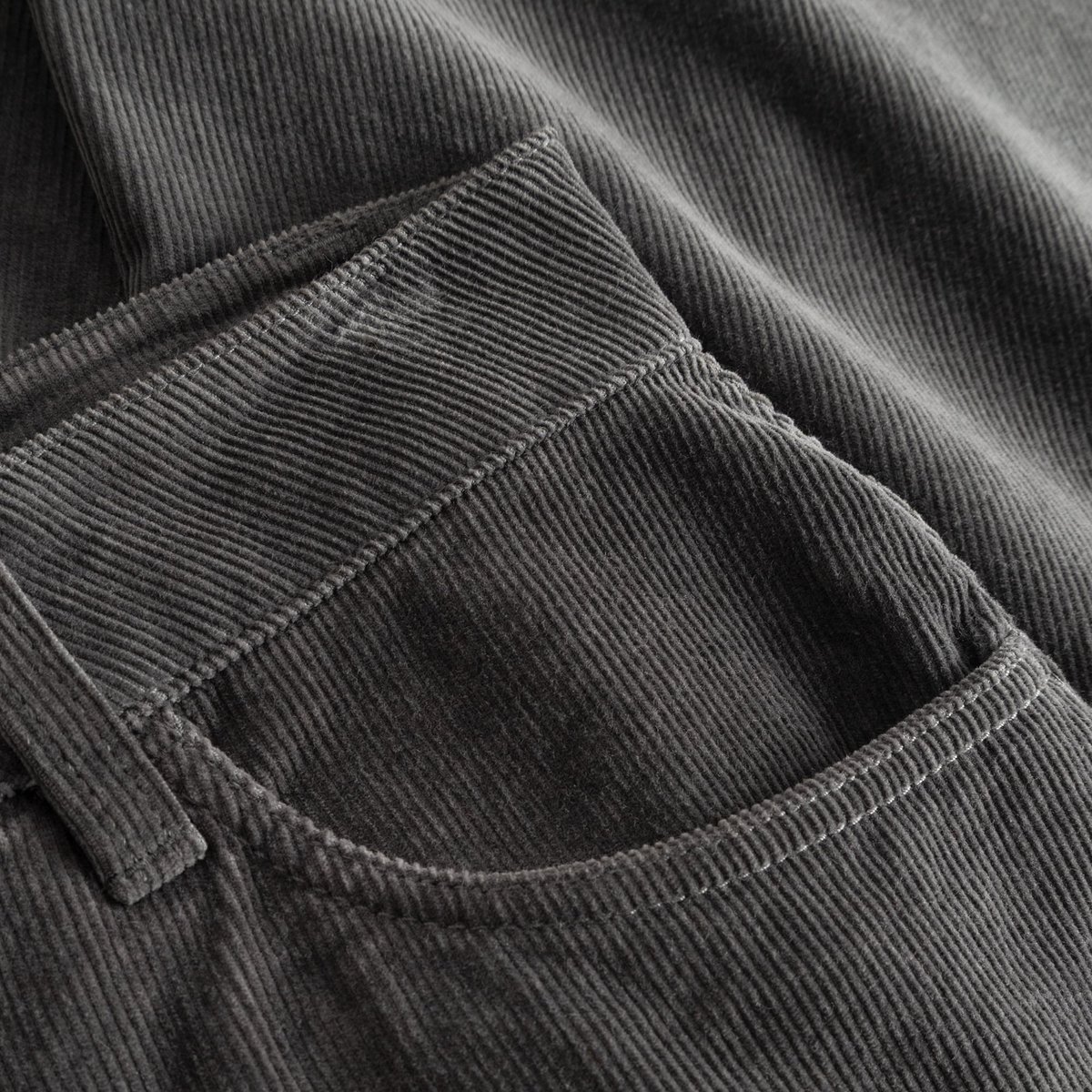 Nahaufnahme der Vordertasche und der feinen Rippenstruktur der Cordhose Ryda in Rock Grey.