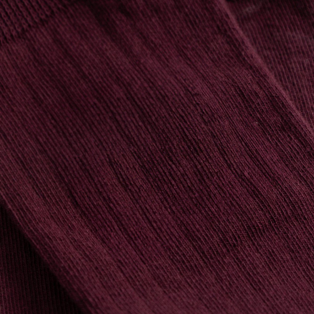 Close-up detail shot of the Rib Socks Knivsta, showing the fine ribbed texture in a deep Fig Red color.