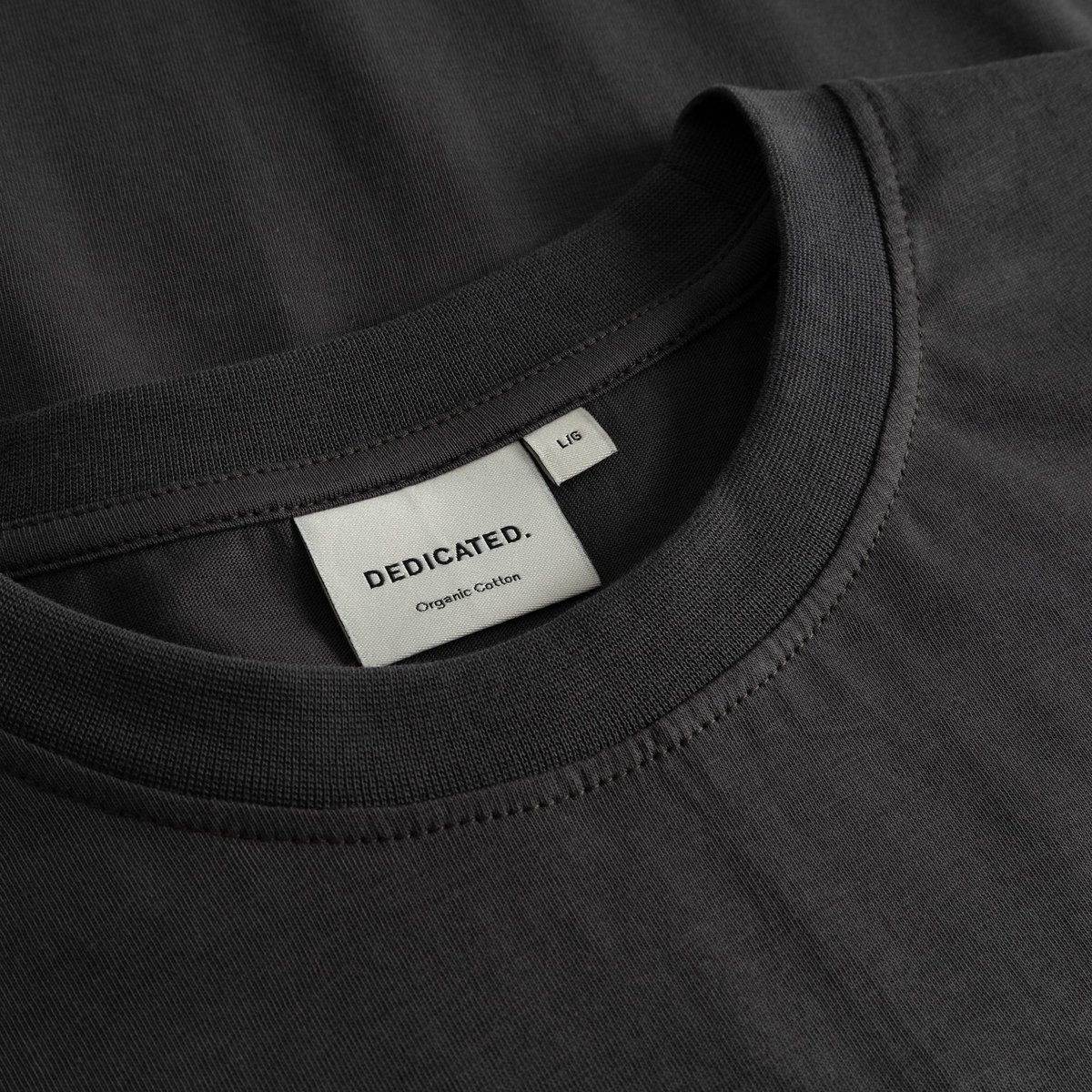 A close-up of the ribbed collar and woven brand label inside the charcoal T-shirt Stockholm Im Fashion.